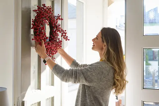 Women-putting-up-wreath-on-door